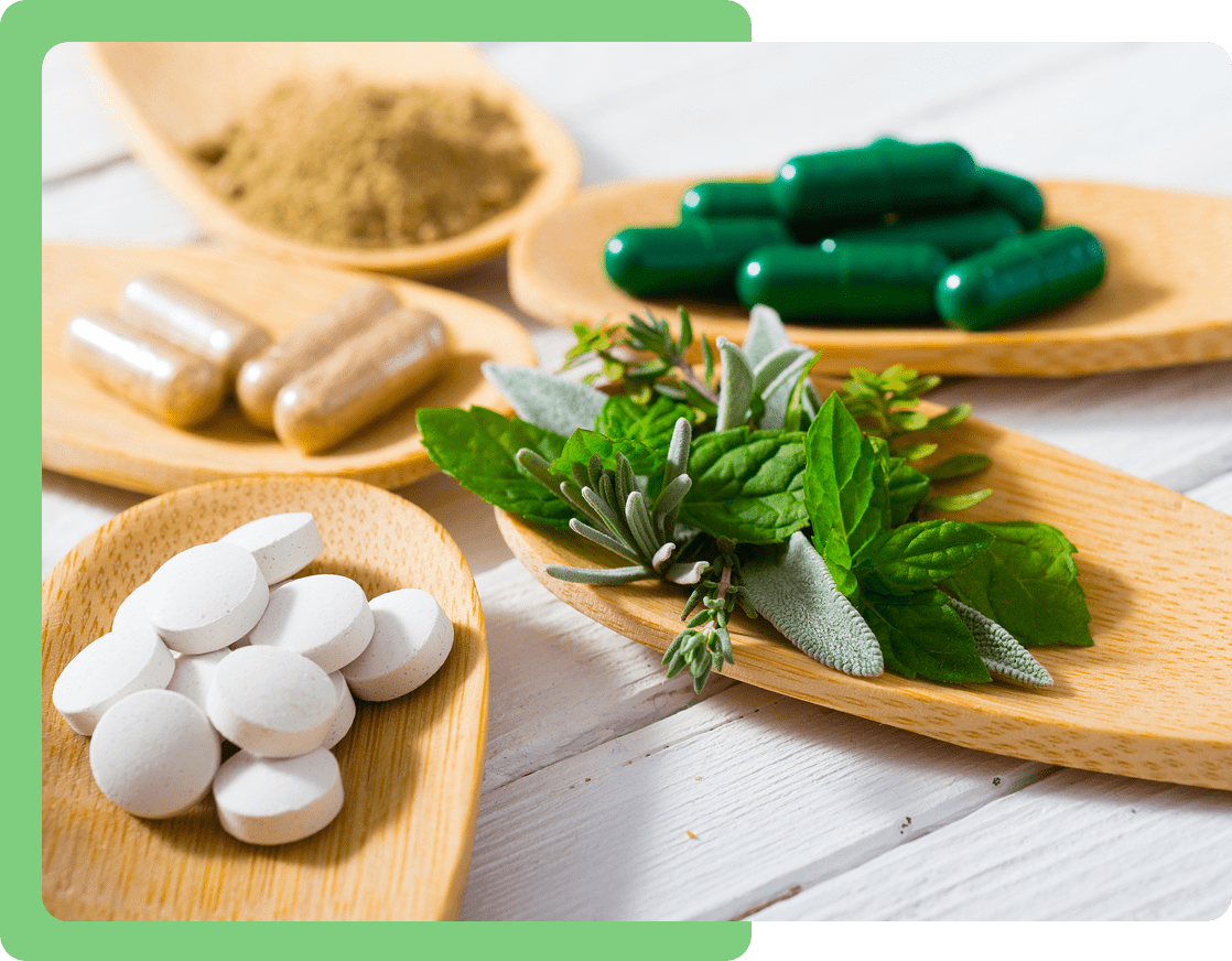 Herbal supplements and capsules on wooden spoons.